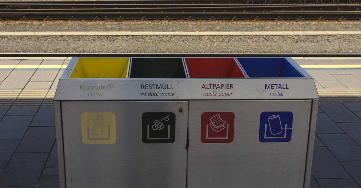 Color-coded recycling bins at a train station, promoting waste separation and environmental sustainability.